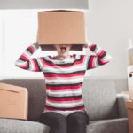 Woman with a moving box on her head.