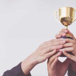 hands holding up winner's trophy