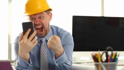A miner reacts to a positive company report mobile phone representing rising iron ore price