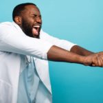 A happy doctor in a white coat dancing due to his excitement over the EBOS acquisition