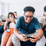 4 teenagers playing mobile game