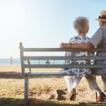 Two retirees sitting on a bench together.