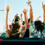 People on a rollercoaster waving hands in the air, indicating a plummeting or rising share price