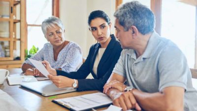 Young professional person providing advise to older couple.
