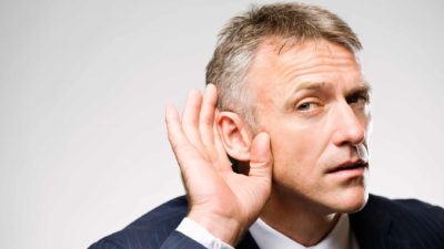 man cupping ear as if to listen closely, rumour, cochlear