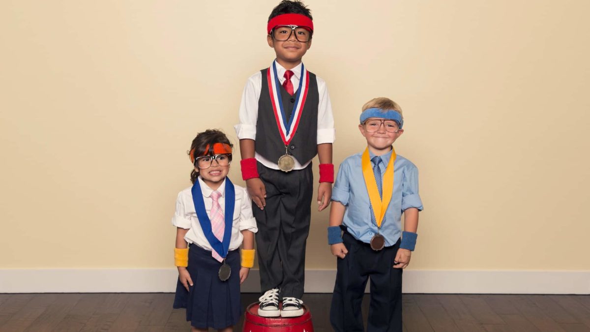 3 children standing on podiums wearing Olympic medals