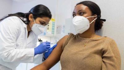 Woman in medical office getting an injection in the arm