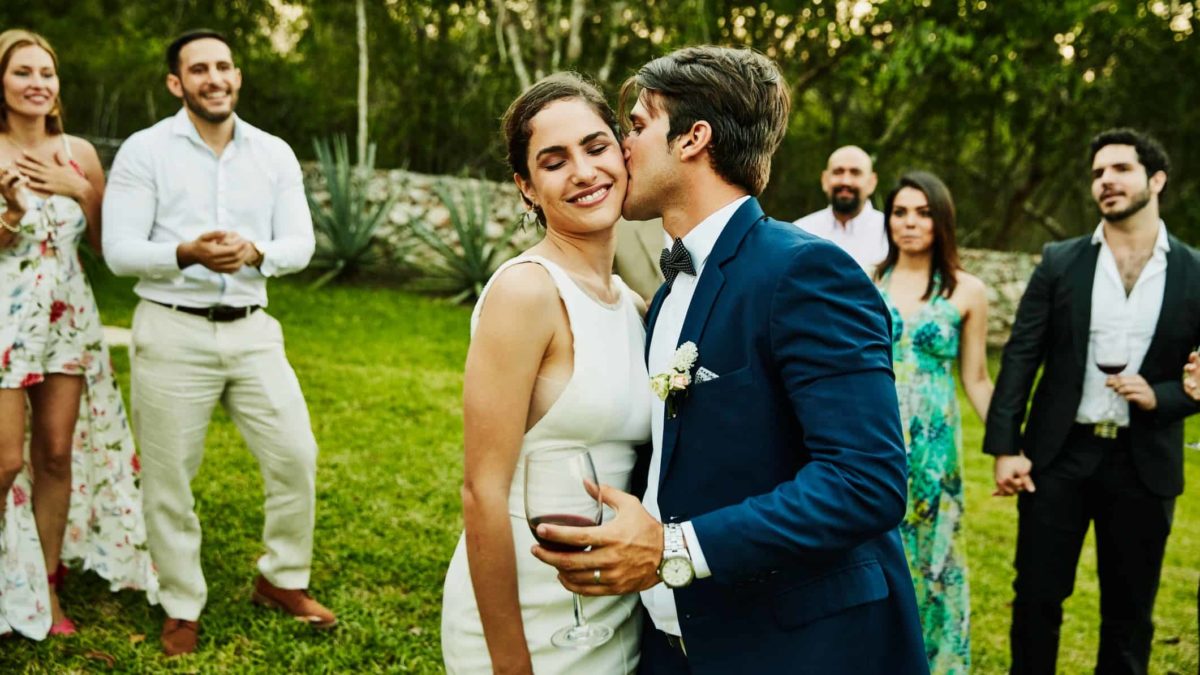 A couple enjoys their wedding day on the lawn.