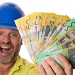 A happy construction worker or miner holds a fistfull of Australian money, indicating a dividends windfall
