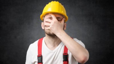 Upset man in hard hat puts hand over face after Armada Metals share price sinks