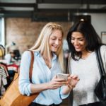 2 women looking at phone