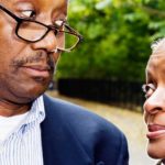 Elderly couple look sideways at each other in mild disagreement