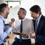 A group of men in the office celebrate after winning big.