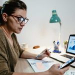 Woman looking at her smartphone and analysing share price.