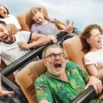 People sit in rollercoaster seats with expressions of fear, terror and exhilaration as it goes into a steep downward descent representing the Novonix share price in FY22