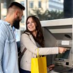 Happy couple at Bank ATM machine.