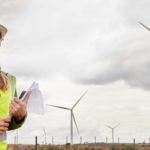 Woman standing in front of a wind farm.