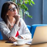 Woman on her laptop thinking to herself.