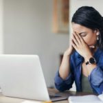 Woman disappointed at share price performance with her hands on her face.