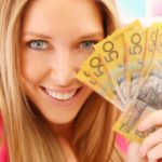 Happy woman holding $50 Australian notes