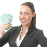 Woman holding $100 Australian notes representing dividends.