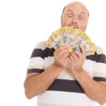 Man looking amazed holding $50 Australian notes, representing ASX dividends.