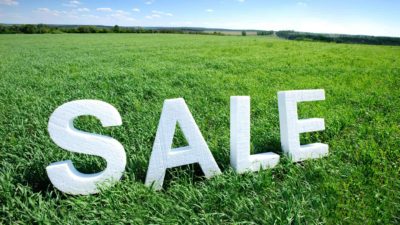 Large green parcel of land with the word sale in big white letters seemingly placed on top of the grass indicating the CSR land sale at Badgerys Creek