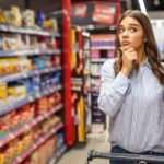 Woman thinking in a supermarket.