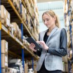 Woman looking at her tablet at a warehouse.