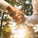 Two people shake hands making a deal about green energy.