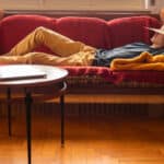 person laying on a couch with a hat, symbolising passive income.