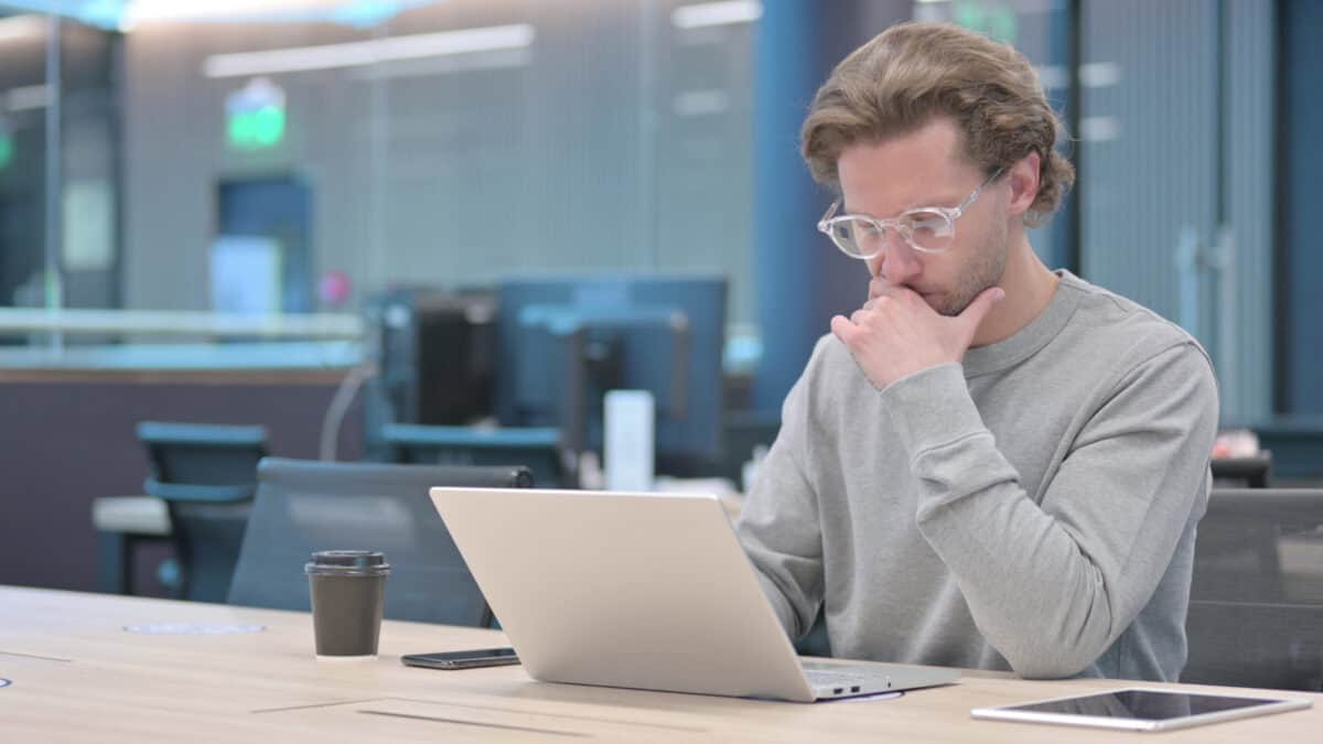 Man on a laptop thinking.