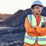 Copal miner standing in front of coal.