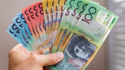 Person holding Australian dollar notes, symbolising dividends.