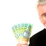 Man holding Australian dollar notes, symbolising dividends.