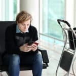 Man waiting for his flight and looking at his phone.