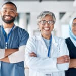 Portrait, confidence and team of doctors in the hospital standing after a consultation or surgery. Success, healthcare and group of professional medical workers in collaboration at a medicare clinic.