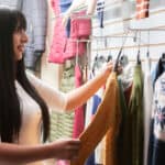 Woman smiling whilst shopping in a clothing store.