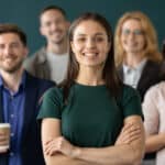 Close up portrait of happy businesswoman standing in front or leading her multi-ethnic corporate team.