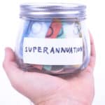 Superannuation written on a jar with Australian dollar notes.