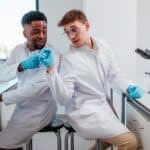 Two lab workers fist pump each other.