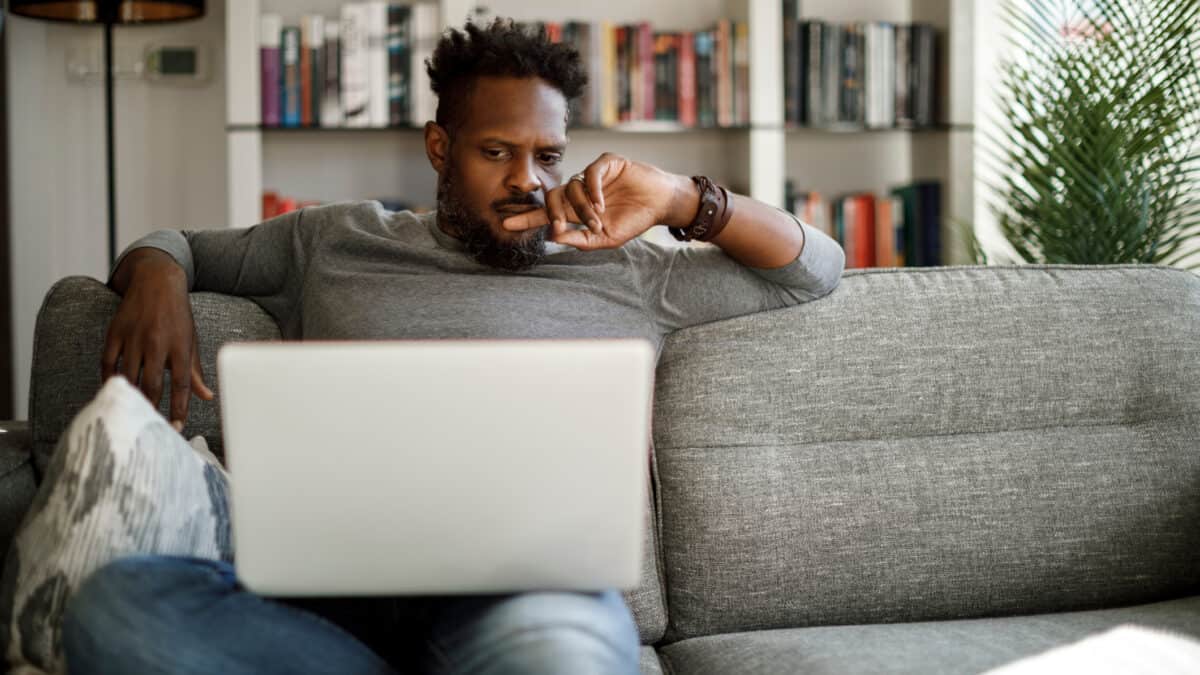 Unsure man analysing data on laptop.