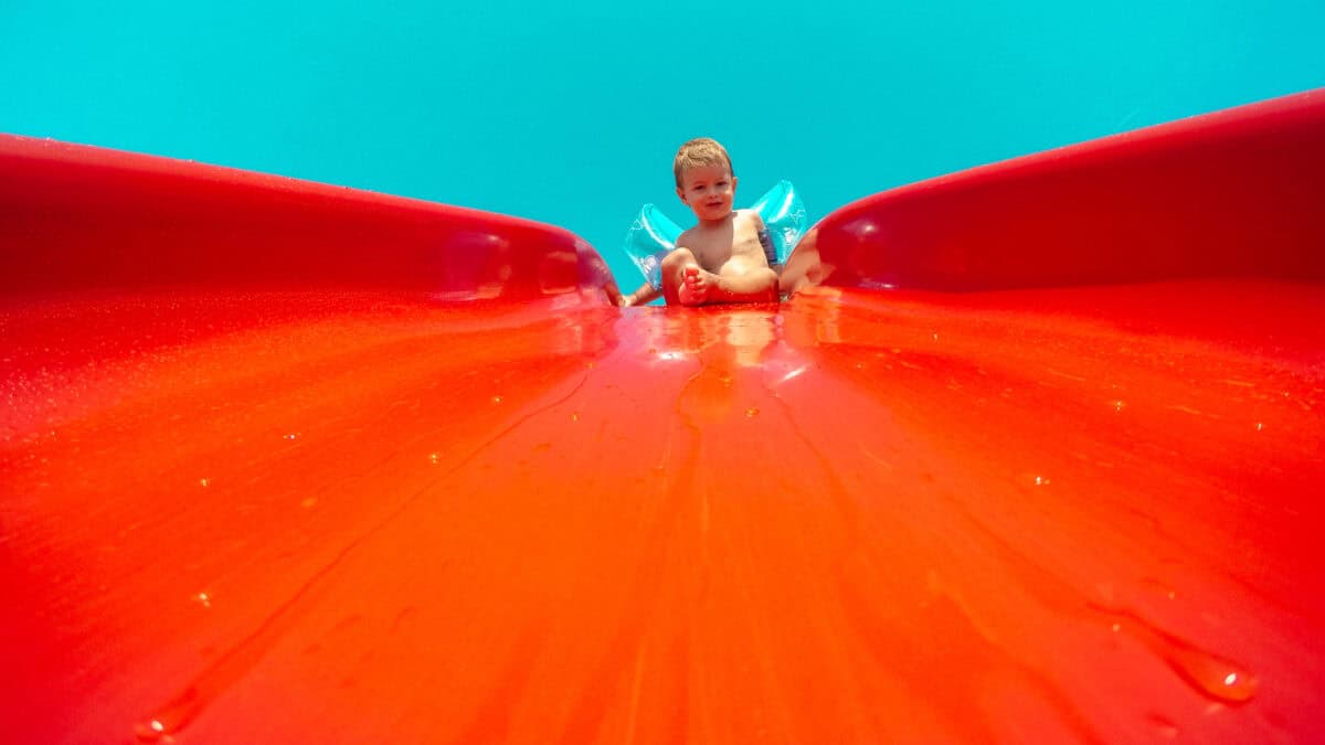 Cute toddler sitting on a water slide.