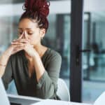 Shot of a young businesswoman looking stressed out while working in an office.