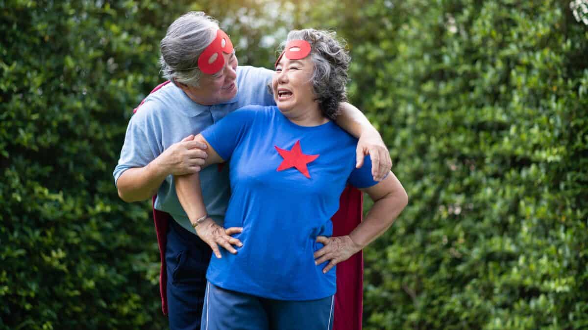 Elderly couple dressed up with capes on.