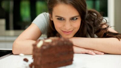 Woman staring at chocolate cake.