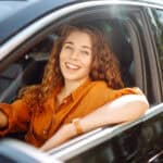 Smiling woman driving a car.