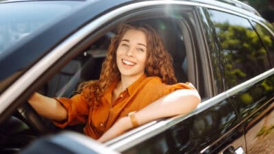 Smiling woman driving a car.