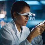 A female engineer inspects a printed circuit board for an artificial intelligence (AI) microchip company.