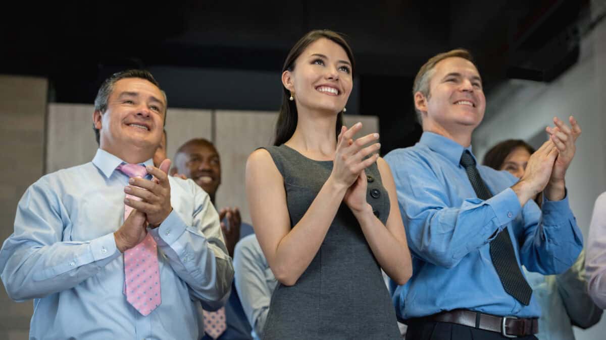 Successful group of people applauding in a business meeting and looking very happy.